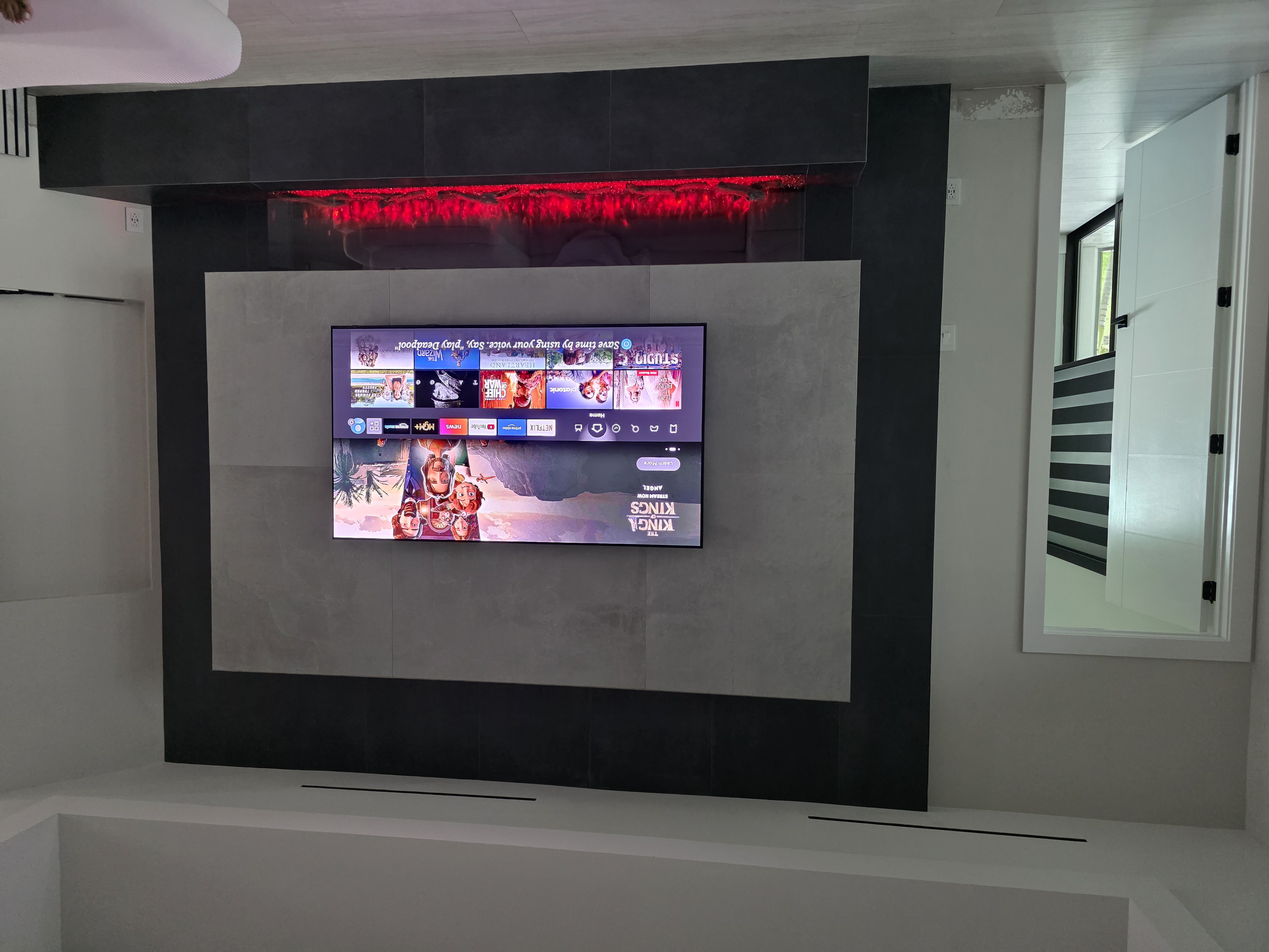 Custom room addition with modern built-in TV and feature wall
